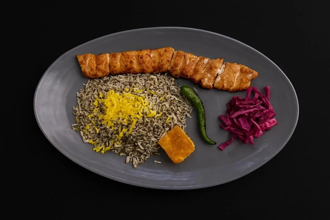 عکس سبزیپلو معطر با جوجهکباب زعفرانی، تهدیگ طلایی، فلفل سبز کبابی و ترشی کلم بنفش؛ سرو در بشقاب خاکستری روی پسزمینه تیره. مناسب منو و سفارش آنلاین رستوران کالانتر.