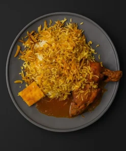 شیرینپلو مجلسی کالانتر؛ برنج زعفرانی با مخلفات شیرین خلالی در کنار مرغ نرم و سس خوشطعم، همراه تکهای تهدیگ طلایی.